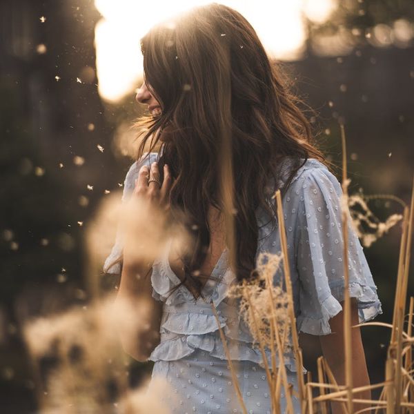 Smiling person stretching outdoors in a park at sunset.